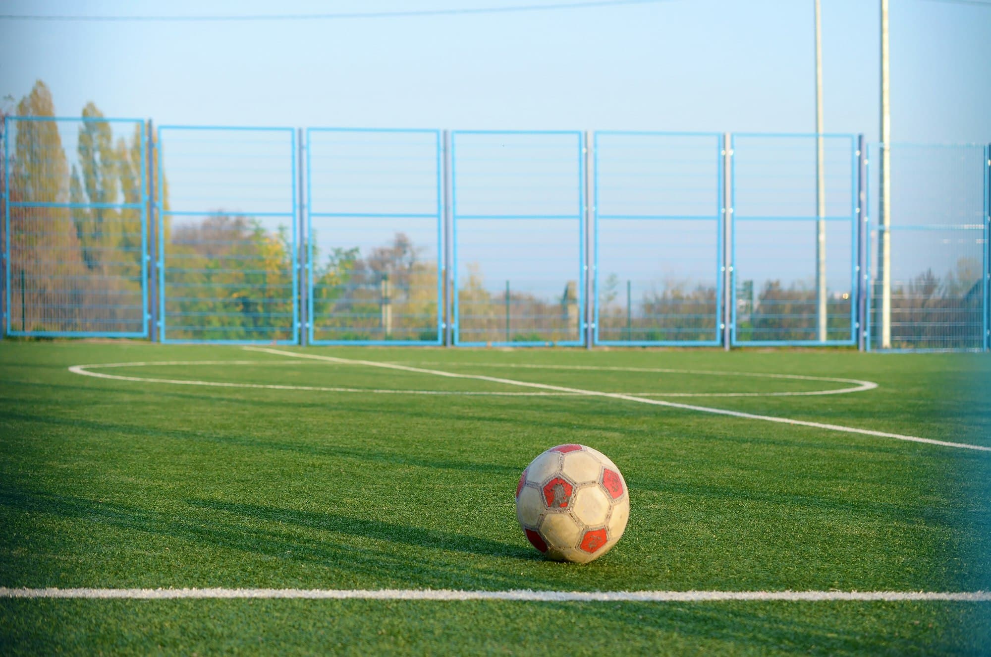 Классический футбольный мяч на футбольном поле с зеленой травой на открытом воздухе