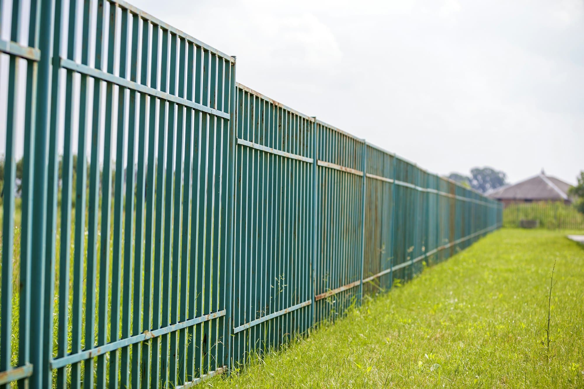 Длинный ржавый старый металлический забор.