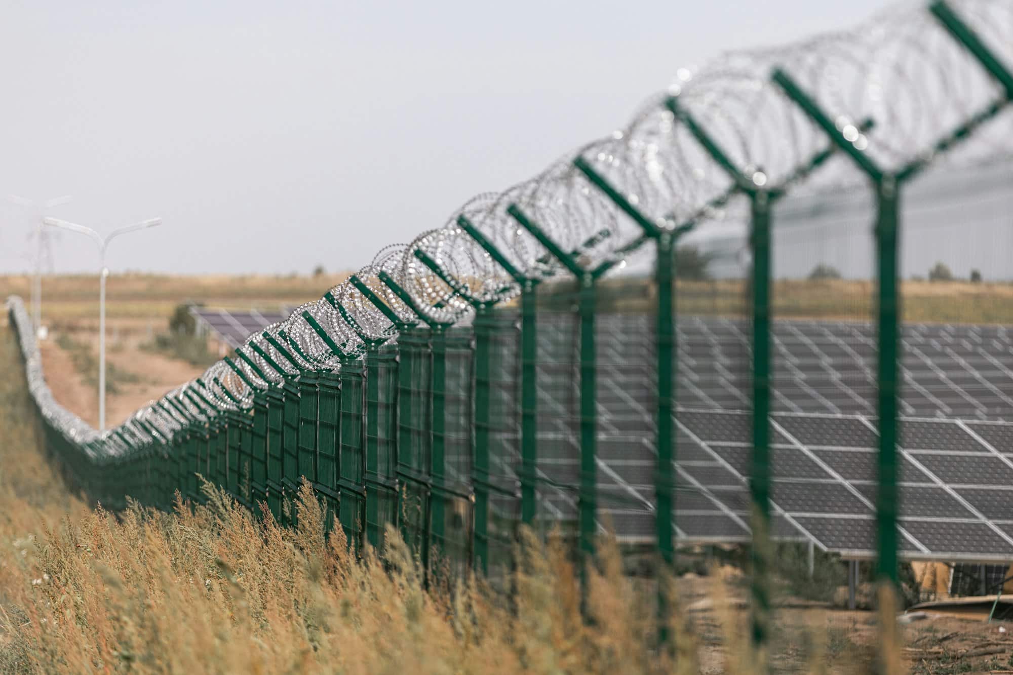 Centrale solare protetta dalla strada tramite recinzione di filo spinato. Recinzione dei siti sensibili con