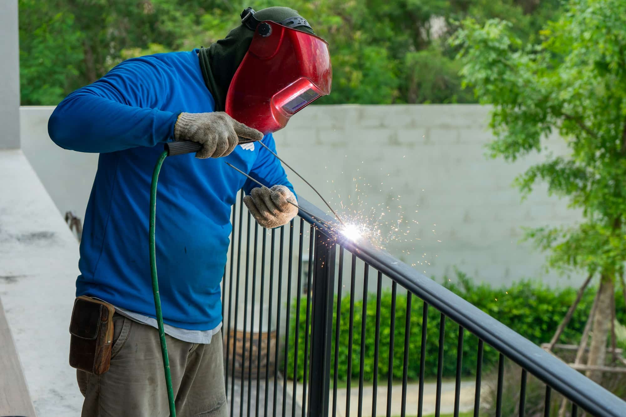 Welder with safety mask welding the steel fence with electrical machine